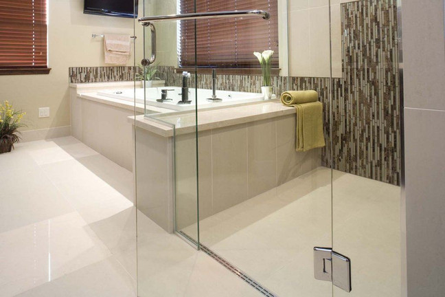 Modern bathroom with a level entry shower with glass enclosure, elegant tile accents, and a soaking tub