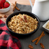 ReadyWise Readywise 52 Serving Emergency Food - Prepper Pack Bucket, a black bowl filled with cooked oatmeal topped with pecans, surrounded by strawberries, cinnamon sticks, and a white pitcher on a table.
