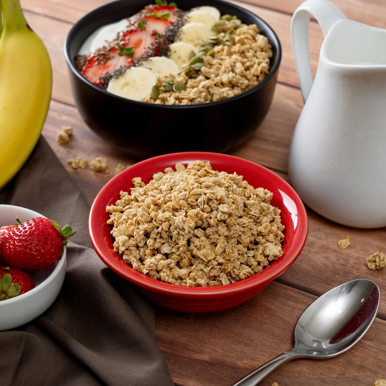 ReadyWise 7-Day Emergency Food Dry Bag - 60 Servings, image shows a prepared breakfast with oats, strawberries, and bananas in a bowl, alongside a bowl of strawberries, a pitcher of milk, and a spoon on a wooden table.