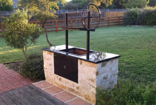 Architectural style Black Steel Santa Maria grill with flange resting on a custom masonry outdoor kitchen counter.