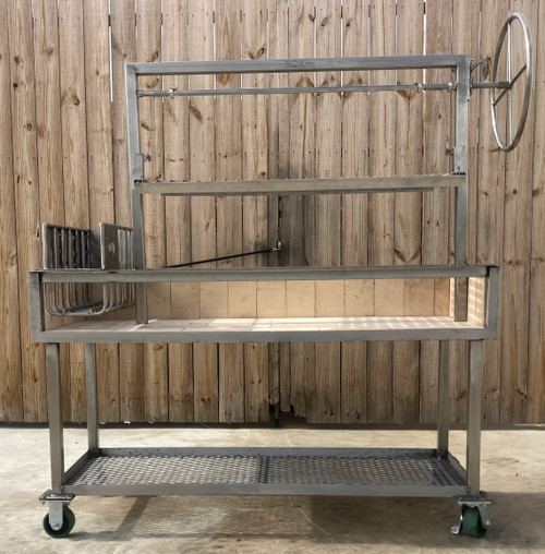 All stainless steel Argentine grill showing its firebrick-lined firebox, side brasero, rotisserie attachment, and mobile cart with casters.