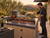 Person cooking meat and vegetables over embers on a 45-inch Uruguayan grill kit with side brasero