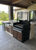 Heavy-duty Argentine Parrilla (grill) designed for outdoor kitchen integration, featuring a prominent, stainless steel wheel for precise control.