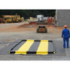 Justrite QuickBerm 14' x 54' x 4" Drive-Through Washdown Spill Containment Berm, 1800 Gallon, Low-Profile for Vehicle & Equipment Cleaning, on dirt construction site with construction equipment and workers in the background.
