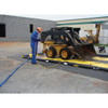 Justrite QuickBerm 14' x 54' x 4" Drive-Through Washdown Spill Containment Berm, 1800 Gallon, Low-Profile for Vehicle & Equipment Cleaning, being rinsed by a worker at a construction site.
