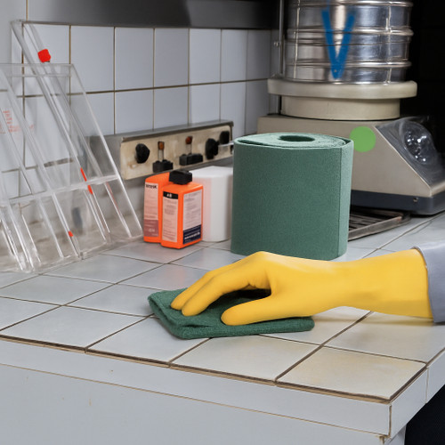 MAPA Professional Latex Gloves, Sure-Grip LF-128 for Cleaning and Food Handling, 20 mil, Flock Lined, 144 pairs, being used for cleaning with a gloved hand wiping a tiled surface.