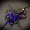Masquerade mask with purple feathers and purple flowers.