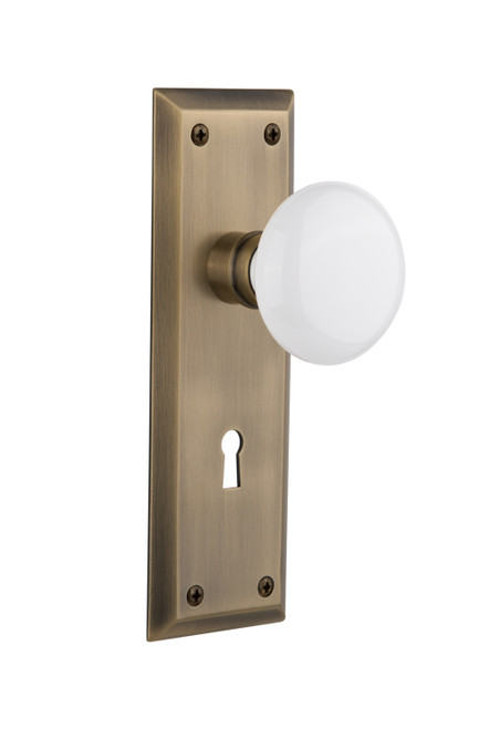 Nostalgic 704640: New York Backplate w/White Porcelain Knob Passage Door Set - Antique Brass