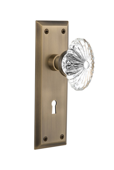 Nostalgic 711835: New York Backplate w/Oval Fluted Clear Glass Crystal Knob Passage Door Set - Antique Brass