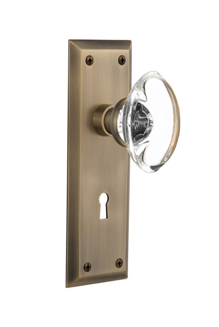 Nostalgic 711491: New York Backplate w/Oval Clear Glass Crystal Knob Single Dummy Door Set - Antique Brass