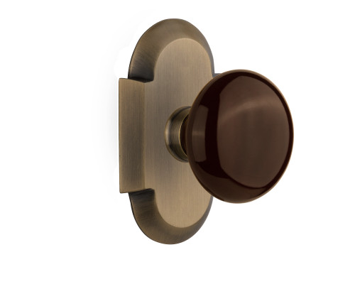Nostalgic 712882: Cottage Backplate w/Brown Porcelain Knob Passage Door Set - Antique Brass