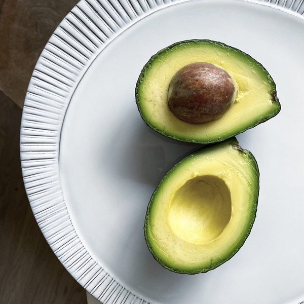 Hass avocado sliced open. Size shown is approx 8oz. 