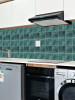 Emerald green peel and stick tiles installed as kitchen splashback with modern cabinets