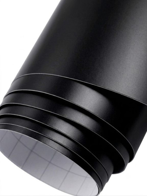 A partially unrolled roll of Layed Matte Black Vinyl Wrap M700, showcasing its smooth, non-reflective matte black finish and the grid-lined self-adhesive backing paper.
