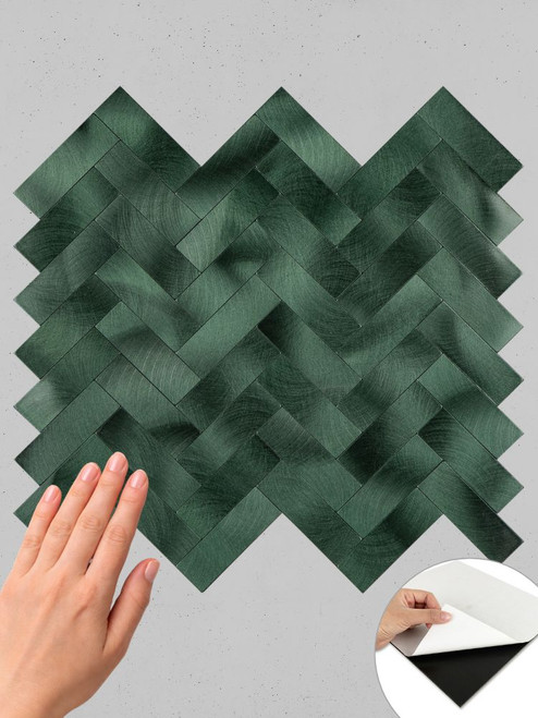 Hand touching the emerald herringbone composite wall tile.