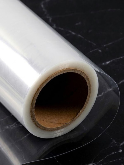 Roll of ultra-clear self-adhesive gloss architectural protection film CPF260 on a dark marble surface