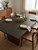 A stylish dining room featuring a table surface beautifully transformed with Java Walnut Wood Vinyl Wrap JWW99, showcasing its rich, deep espresso brown wood grain finish.