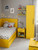A playful, space-themed child's bedroom featuring a bed frame, nightstand, tall wardrobe, and floating shelves all vibrantly unified using the Matte Textured Canary Yellow Vinyl Wrap MTCY74, contrasting beautifully against soft grey walls.