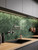 Dark modern kitchen featuring an emerald green metal herringbone peel and stick tile backsplash.