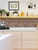 Minimalist kitchen with modern plywood cabinets, an espresso machine, and a geometric 3D copper peel and stick tile backsplash.