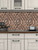 Close-up of a kitchen space featuring white wood-grain cabinets, a dark countertop, and a geometric 3D copper metallic wall tile.