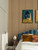 Stylish modern bedroom featuring a blue velvet bed, framed artwork, and a floor-to-ceiling golden maple wood slat accent wall.