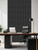 Modern home office featuring a wooden desk and black leather executive chair set against an ebony black peel and stick slat accent wall.