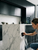 Installer using a squeegee to apply clear gloss surface protection vinyl CPF260 onto a white marble kitchen island