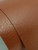 A macro close-up of Layed Tan Leather Vinyl Wrap LR801, highlighting the deeply embossed, highly realistic faux leather grain pattern and warm tan color.