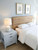 A bright, airy bedroom setting showcasing a custom bed headboard flawlessly upgraded using Layed White Oak Wood Vinyl Wrap.