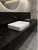 A contemporary bathroom vanity featuring a crisp white vessel sink set against a striking dark countertop and backsplash wrapped in Layed Royal Black Satin Marble Vinyl Wrap.