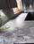 A bright kitchen featuring white gloss cabinets beautifully contrasted by a dark, moody countertop covered in Layed Orobico Grey Marble Vinyl Wrap.