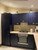 A full view of a modern kitchen showcasing a tall pantry unit and matching cabinets flawlessly upgraded using the deep, light-catching tones of Layed Brushed Metal Navy Blue Vinyl Wrap.