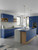 A modern kitchen featuring cabinets and a two-tone island beautifully transformed with Layed Matte Textured Royal Blue Vinyl Wrap, paired with a white hex tile backsplash and light wood accents.