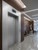 A modern commercial lobby featuring elevator doors and surrounds flawlessly resurfaced with Layed Satin Textured Silver Vinyl Wrap STS25, contrasting beautifully with rich wood wall paneling.