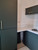 Close-up of upper and lower kitchen cabinets wrapped in Layed Matte Silk Dark Olive Green vinyl, showcasing the smooth factory-like finish.