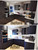 A stunning before and after kitchen makeover comparison, showing glossy dark grey cabinets transformed into a modern matte navy blue finish using Layed Vinyl Wrap.