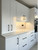 Close-up of modern kitchen cabinets completely wrapped in Layed Matte Silk White vinyl, beautifully contrasting with matte black handles.