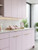 A modern kitchen transformation featuring cabinets newly finished in Layed premium interior matte vinyl wrap in pastel pink.