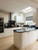 Complete kitchen transformation showcasing Layed Matte Silk Ivory Vinyl Wrap on cabinetry, pairing elegantly with a sleek black countertop and wood flooring.