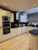 A spacious modern kitchen featuring base cabinets and an island flawlessly wrapped in Layed Matte Silk Ivory vinyl.