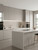 A luxurious modern kitchen interior featuring an island and cabinets completely resurfaced with Layed Matte Textured Greige Vinyl Wrap MTG416.