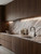 A modern worktop and Backsplash wrapped in Brown Marble Vinyl Wrap BM301 from layed, displaying its highly realistic, flowing earthy brown and cream marble pattern.