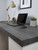A modern home office setup featuring a thick desk surface completely upgraded with the durable, industrial look of Layed Grey Cement Vinyl Wrap.