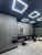 A modern barbershop interior featuring a striking feature wall seamlessly covered in Layed Grey Cement Vinyl Wrap for an edgy, industrial aesthetic.