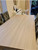 Close-up of a dining table surface highlighting the realistic, tactile light wood grain finish of Layed Washed Oak Wood Vinyl Wrap.