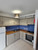 A cozy kitchen space featuring shaker-style cabinets flawlessly upgraded with Layed Painted Wood Tan Vinyl Wrap, contrasting beautifully with a vibrant blue mosaic tile backsplash.