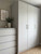 A modern bedroom setting showcasing a tall freestanding wardrobe and matching dresser seamlessly transformed with the tactile, light grey finish of Layed Silver Fabric Vinyl Wrap.