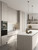 A bright, modernized kitchen space featuring cupboards wrapped in a textured painted wood vinyl finish.