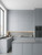 Modern cupboards wrapped in a textured grey painted wood vinyl finish.